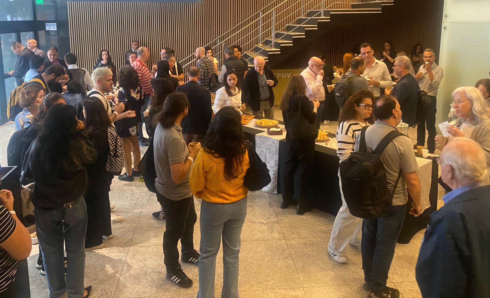 Participants networking and chatting during a coffee break at the Crossref São Paulo event.